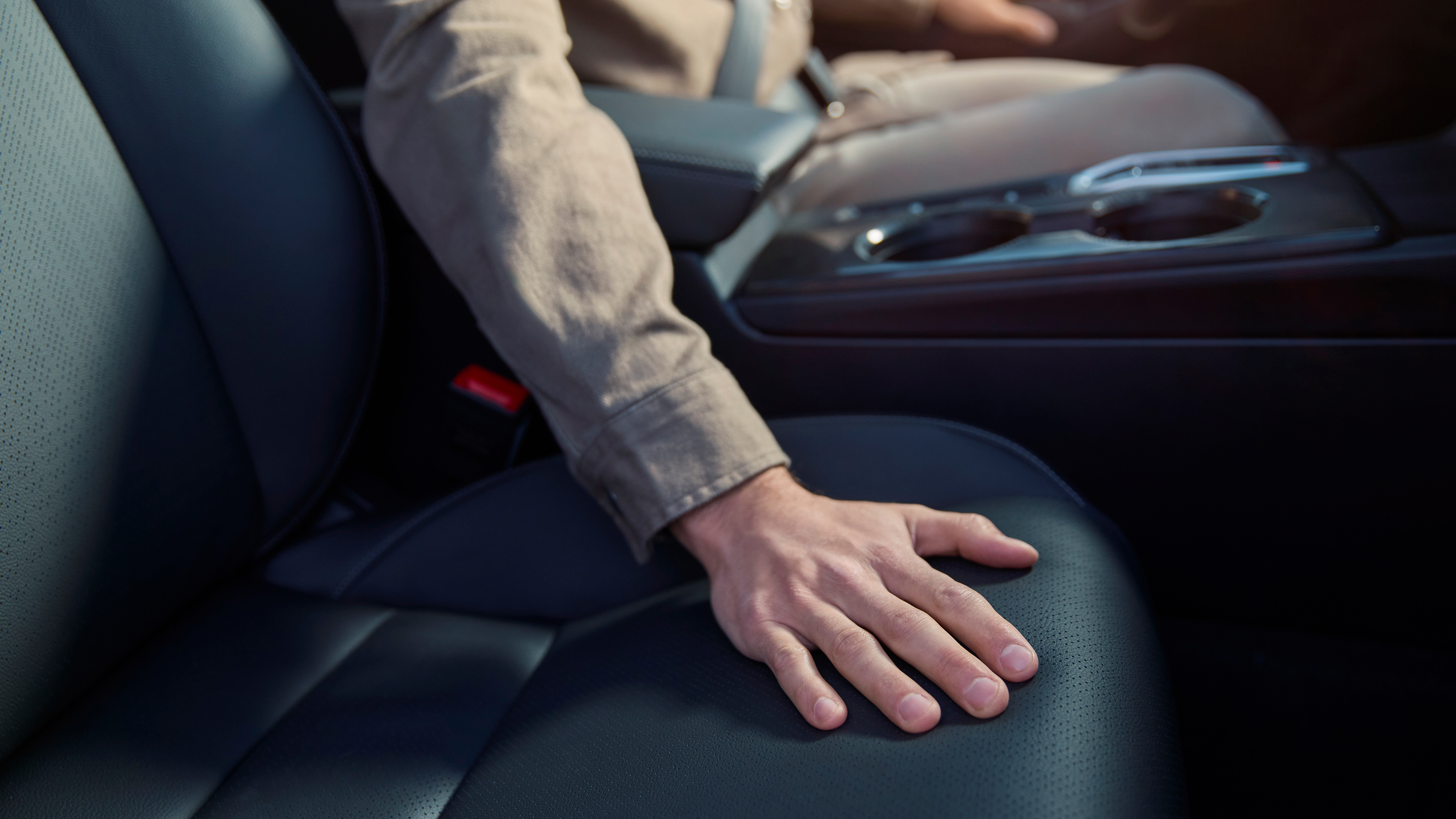 Primer plano de una persona con una mano en el asiento del Honda Civic Hybrid.